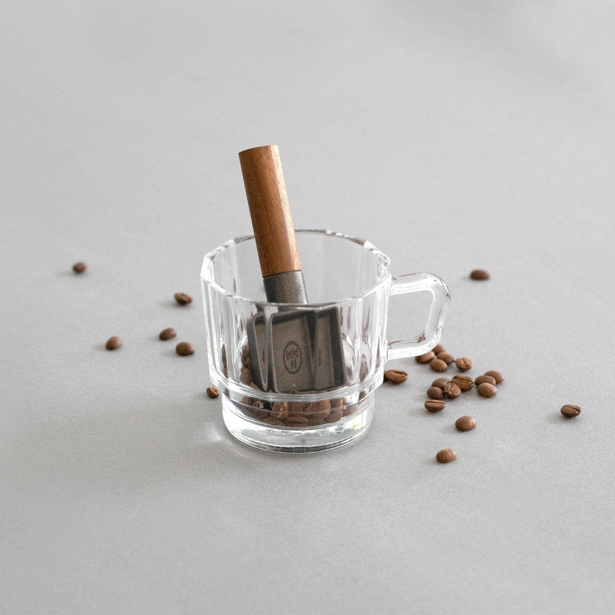 A cast iron coffee scoop with walnut wood handle.