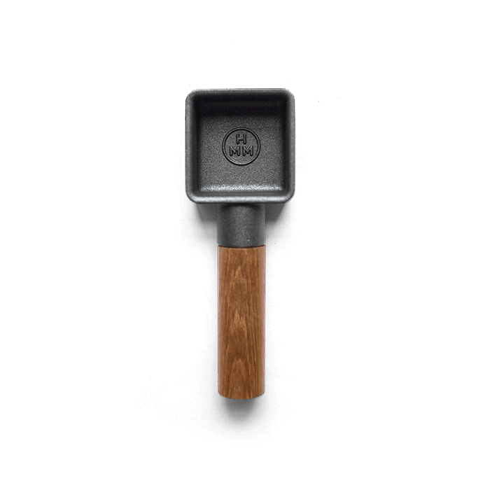 A cast iron coffee scoop with walnut wood handle.