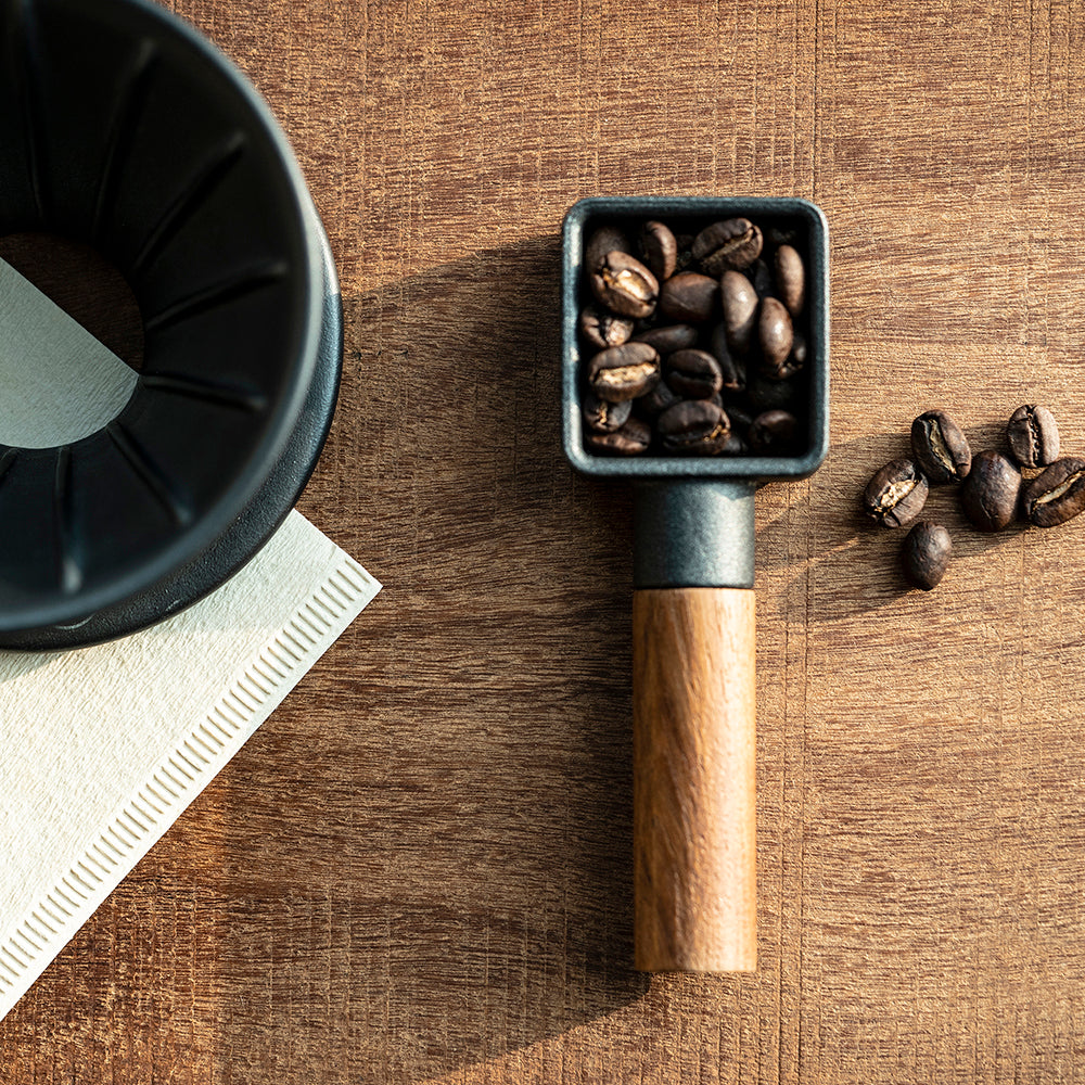 A cast iron coffee scoop with walnut wood handle. 10 grams per scoop.